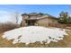 Exterior view of the home's backyard featuring a covered patio and landscaped grounds at 1039 Buffalo Ridge Way, Castle Pines, CO 80108