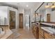 Bathroom with dual sinks, marble countertops, soaking tub, and glass-enclosed shower at 1039 Buffalo Ridge Way, Castle Pines, CO 80108