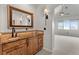 Bathroom vanity with marble countertop, framed mirror, and stylish sconces at 1039 Buffalo Ridge Way, Castle Pines, CO 80108