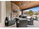 Cozy covered patio with stone fireplace, wood ceiling, and comfortable seating area for outdoor gatherings at 1039 Buffalo Ridge Way, Castle Pines, CO 80108