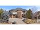 Stately two-story house featuring stone accents, mature trees, and a large driveway at 1039 Buffalo Ridge Way, Castle Pines, CO 80108