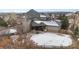 Rear aerial view of a home with a covered patio and snow-covered backyard at 1039 Buffalo Ridge Way, Castle Pines, CO 80108