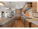 Well-equipped kitchen with an island, gas range, and granite countertops with an archway to the living room at 1039 Buffalo Ridge Way, Castle Pines, CO 80108