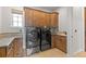 Functional laundry room with washer, dryer, and custom wood cabinets at 1039 Buffalo Ridge Way, Castle Pines, CO 80108