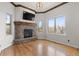 Cozy living room features a stone fireplace, hardwood floors, and large windows with natural light at 1039 Buffalo Ridge Way, Castle Pines, CO 80108