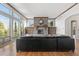 Bright living room with floor to ceiling windows, stone fireplace, and a comfortable, oversized couch at 1039 Buffalo Ridge Way, Castle Pines, CO 80108