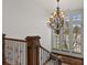 Elegant staircase with iron railings, wood accents, and an ornate chandelier and bright windows at 1039 Buffalo Ridge Way, Castle Pines, CO 80108