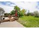 View of backyard featuring deck with outdoor seating, spacious lawn, and mature trees at 9376 W Wagon Trail Cir, Littleton, CO 80123