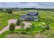 Aerial view of two-story home with solar panels, a front porch, and mature trees at 43793 Buckskin Rd, Parker, CO 80138
