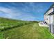 Expansive backyard featuring green grass, partial fencing, a patio, and views of the surrounding landscape at 43793 Buckskin Rd, Parker, CO 80138