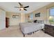 Bright main bedroom featuring neutral carpet, ceiling fan, and nightstands at 43793 Buckskin Rd, Parker, CO 80138