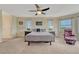 Bright main bedroom with ceiling fan, neutral carpet, and views of the surrounding green space at 43793 Buckskin Rd, Parker, CO 80138