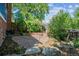 Relaxing stone patio with fire pit, landscaping, and wooden fence at 3824 S Xenia St, Denver, CO 80237