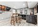 Basement bar with seating and storage; features hardwood-style floors at 3824 S Xenia St, Denver, CO 80237