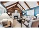 Living room features vaulted ceiling, exposed beams, and a rustic fireplace wall at 3824 S Xenia St, Denver, CO 80237