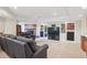 Cozy basement with a brick fireplace, built-in bookshelves, and a comfortable black leather sofa at 15573 E Prentice Ln, Centennial, CO 80015