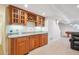 Basement wet bar with custom cabinets, granite countertop, sink, and refrigerated beverage center at 15573 E Prentice Ln, Centennial, CO 80015