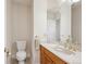 Cozy half bathroom featuring a pristine white toilet, elegant marble countertop, and timeless vanity at 15573 E Prentice Ln, Centennial, CO 80015
