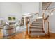 Bright foyer featuring a curved staircase, hardwood floors, and views of the living room at 15573 E Prentice Ln, Centennial, CO 80015