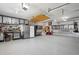 Spacious three-car garage with epoxy floor, cabinets, and workbench area at 15573 E Prentice Ln, Centennial, CO 80015
