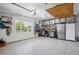 Three car garage with epoxied flooring, cabinets, workspace, and natural light at 15573 E Prentice Ln, Centennial, CO 80015