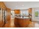 Spacious kitchen featuring wood cabinets, granite countertops, and a large center island at 15573 E Prentice Ln, Centennial, CO 80015
