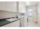 Bright laundry room with ample storage, modern washer, and dryer units, designed for efficient household tasks at 15573 E Prentice Ln, Centennial, CO 80015