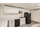 Basement kitchenette featuring a sink, black refrigerator, and white cabinets with marble countertop at 3361 S Dahlia St, Denver, CO 80222