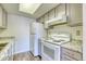 Bright kitchen includes white appliances and neutral gray cabinetry at 6007 Yarrow St # D, Arvada, CO 80004