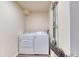 Functional laundry room with a washer, dryer, and storage for cleaning supplies at 6007 Yarrow St # D, Arvada, CO 80004