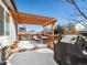 Inviting outdoor deck featuring a pergola, comfortable seating, and a tranquil atmosphere in winter at 6308 Walnut Grove Way, Erie, CO 80516