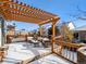 Inviting outdoor deck featuring a pergola, comfortable seating, and a tranquil atmosphere in winter at 6308 Walnut Grove Way, Erie, CO 80516