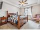 This well-lit bedroom has a plush chair, tray ceiling, and a beautiful bed frame at 6308 Walnut Grove Way, Erie, CO 80516