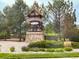 Stone Wyndham Hill entrance with lush landscaping and wooden fence at 6308 Walnut Grove Way, Erie, CO 80516