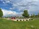 Community playground with swings, slide, play structure, and picnic tables, set against a backdrop of neighborhood homes at 6308 Walnut Grove Way, Erie, CO 80516