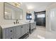 Modern bathroom with double vanity, stylish mirrors, lighting and a glass enclosed shower at 1346 Steele St, Denver, CO 80206
