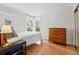 Bright bedroom featuring hardwood floors, a vintage dresser, and sun-filled windows at 1346 Steele St, Denver, CO 80206