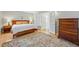 Bedroom with a wood bed frame, neutral bedding, a decorative rug and French doors to the ensuite bathroom at 1346 Steele St, Denver, CO 80206