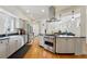 Modern open kitchen with stainless appliances, farmhouse sink, and view to the living room at 1346 Steele St, Denver, CO 80206