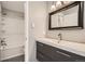 Modern bathroom featuring sleek vanity with sink, large mirror, and walk-in shower/tub combination at 13158 W 62Nd Dr, Arvada, CO 80004