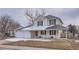 Attractive two-story home featuring a covered front porch and a three car garage at 13158 W 62Nd Dr, Arvada, CO 80004