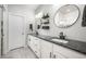 Bathroom featuring double sinks with dark countertops, white cabinets, and modern lighting fixtures at 11524 Dewey St, Parker, CO 80138