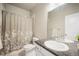 Bathroom with white cabinets, granite countertops, and a shower with patterned curtain at 11524 Dewey St, Parker, CO 80138