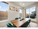 Bright dining room with a wooden table, six teal chairs, and sliding door access to the backyard at 11524 Dewey St, Parker, CO 80138