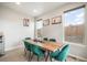 Sunlit dining room with a wooden table, teal chairs, and a modern aesthetic at 11524 Dewey St, Parker, CO 80138