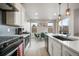 Well-lit kitchen features stainless steel appliances, an island with seating, and a view to the outdoor fenced in yard at 11524 Dewey St, Parker, CO 80138