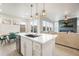 Bright kitchen with an island overlooks the open-concept living area with a fireplace and plentiful natural light at 11524 Dewey St, Parker, CO 80138