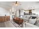 Bright, open-concept living space featuring a large sectional, wooden coffee table, and modern lighting at 11524 Dewey St, Parker, CO 80138