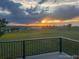 View from back deck with sunset over distant green field with black fence at 46531 Sundance Trl, Parker, CO 80138