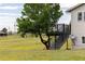 A home backyard with a deck, lawn and a mature tree at 46531 Sundance Trl, Parker, CO 80138